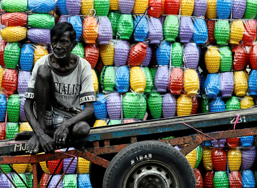 A man rests on his cart after unloading plastic jugs near a shop at a main market in Colombo