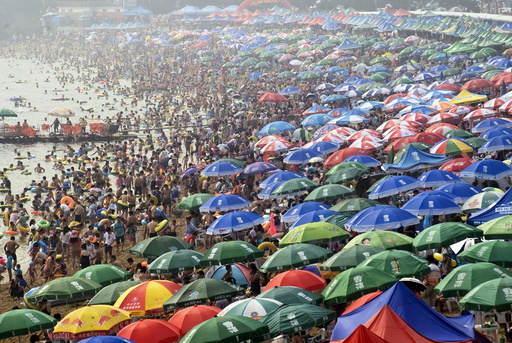 People crowd on a beach to escape the summer heat on a hazy day in Dalian, Liaoning province, China