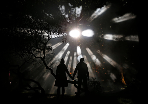 Visitors pose for a photograph during the Enchanted Christmas event at the Forestry Commission's National Arboretum in Westonbirt