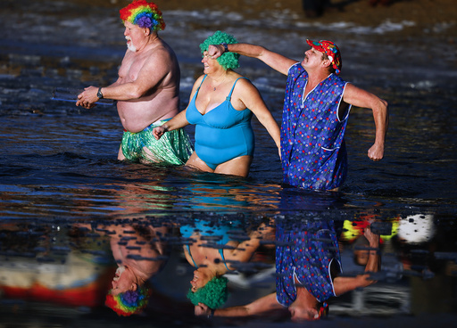 Members of an ice swimming club take a dip in the lake Orankesee during the annual carnival swimming meeting in Berlin