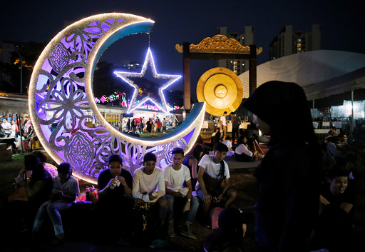 Youths break their fast at a bazaar ahead of Eid al-Fitr, which marks the end of the holy month of Ramadan, in Singapore