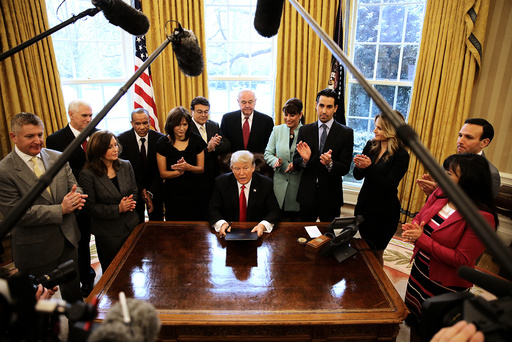 U.S. President Donald Trump signs an executive order cutting regulations, accompanied by small business leaders at the Oval Office of the White House in Washington U.S.
