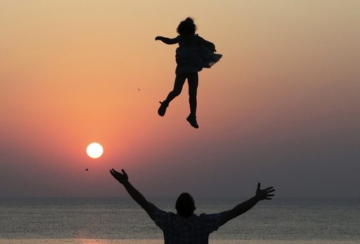 Man throws a girl into the air during sunset as they spend time on the territory of Chersonesus Tavrichesky National Reserve in Sevastopol