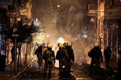 Fireworks explode next to riot police during clashes following an anniversary rally marking the 2008 police shooting of 15-year-old student, Alexandros Grigoropoulos, in Athens