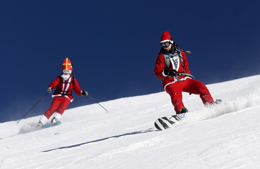 People, dressed as Santa Claus, take a curve during a promotional event on the opening weekend in the alpine ski resort of Verbier