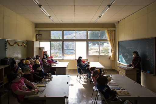 Scarecrows representing former pupils and a teacher sit in a classroom in a closed down school in the village of Nagoro
