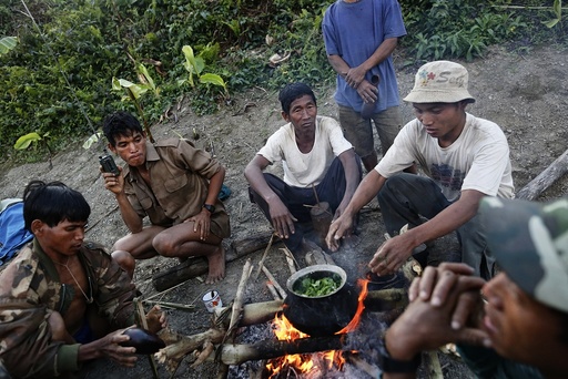 Naga men prepare dinner at a hunting base camp in an opium field during a hunting trip between Donhe and Lahe township in the Naga Self-Administered Zone