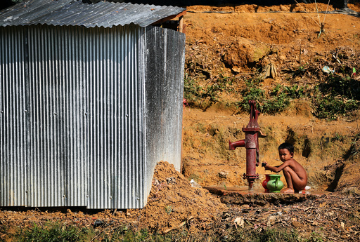 A Rohingya refugee boy fetches water from a water pump in Kutupalong refugee camp near Cox's Bazar
