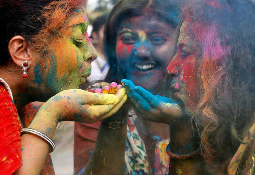 Students of Rabindra Bharati University blow colour powder during Holi, the Festival of Colours, celebrations inside the university campus in Kolkata