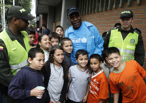 UNICEF Goodwill Ambassador and actor Glover poses with children after his arrival at a soccer stadium in Envigado