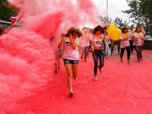 Participants run through coloured powder during the YARKOcross colour run race in Almaty