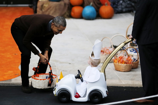 U.S. President Barack Obama receives a child dress as the Pope Francis on the South Lawn of the White House during a Halloween trick-or-treating celebration in Washington