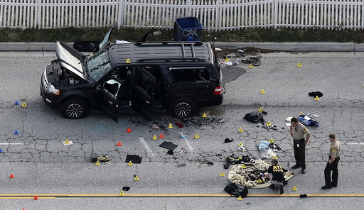 Law enforcement officers look over the evidence near the remains of a SUV involved in the Wednesdays attack is shown in San Bernardino, California