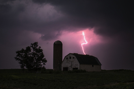 Lighting strikes over a barn surrounded by a soybean crop in Donnellson, Iowa