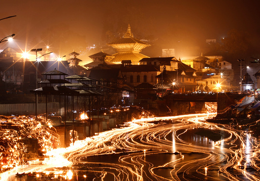 Oil lamps offered by devotees illuminate the Bagmati River flowing through the premises of the Pashupatinath Temple, during the Bala Chaturdashi festival, in Kathmandu