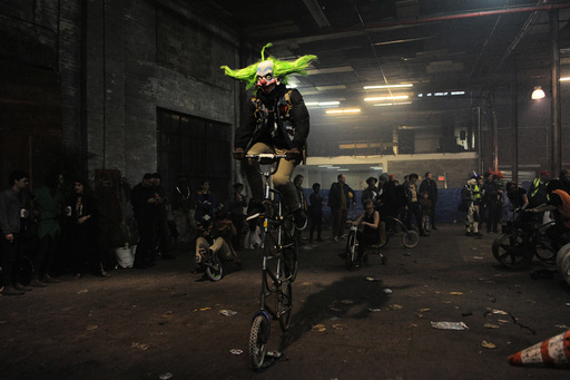 People ride bicycles in Halloween costumes during 