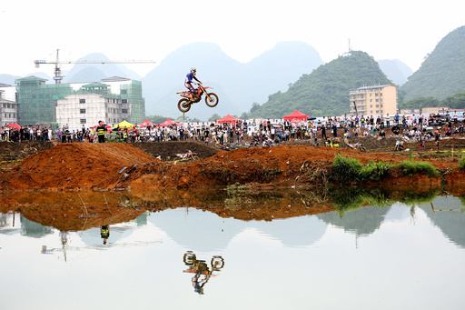 A rider rides a motorcycle in the air during a competition at Guilin