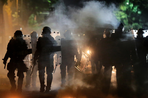 Riot policemen walk past a barricade on fire after a clash with ant-government demonstrators during a protest against Brazilian social welfare reform project, in Rio de Janeiro