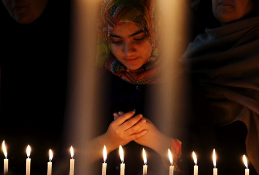 A girl prays for the victims of a militant attack on the Bacha Khan University, during a candle light vigil in Peshawar, Pakistan