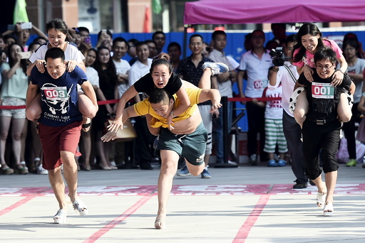 A couple fall as they take part in a high-heels race in Taiyuan