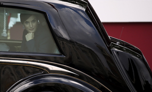 Spanish Queen Letizia leans on the window as she leaves with Spanish King Felipe after a military parade marking Spain's National Day in Madrid