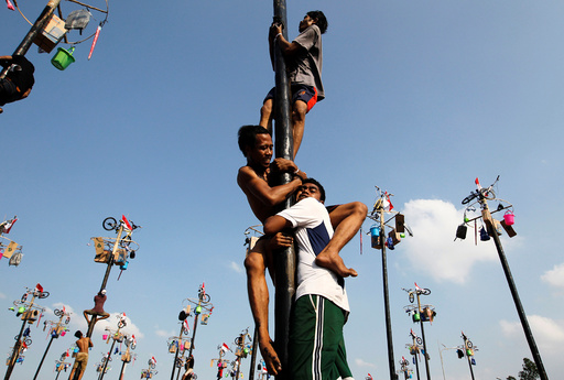 Participants climb greased poles to collect prizes during a Panjat Pinang event organised in celebration of Indonesia's 71st Independence day in Jakarta, Indonesia