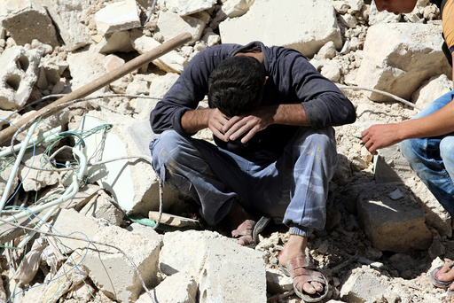 A man reacts on the rubble of damaged buildings after losing relatives to an airstrike in the besieged rebel-held al-Qaterji neighbourhood of Aleppo