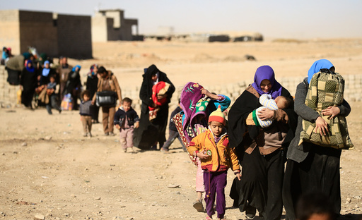 Displaced people fleeing from Islamic State militants in Tahrir neighborhood, walk in Mosul