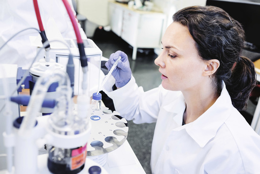 Female scientist using pipette in laboratory