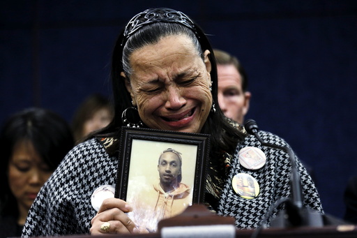 Miyoshia Bailey of Chicago struggles to speak while holding a photo of her slain son Cortez, during a press conference on gun violence in the U.S. Capitol in Washington