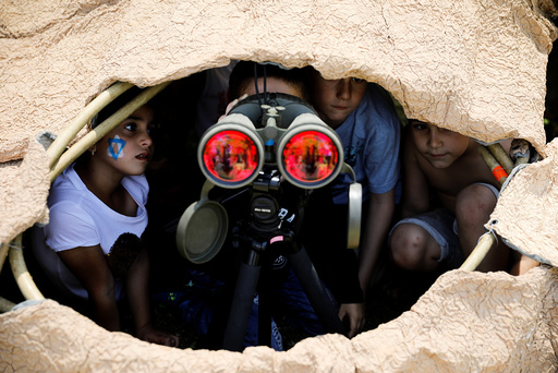 Israeli children look through binoculars during a display of Israeli Defense Forces equipment and abilities, as part of the celebrations for Israel's Independence Day marking the 69th anniversary, in the southern city of SderotChildren loo