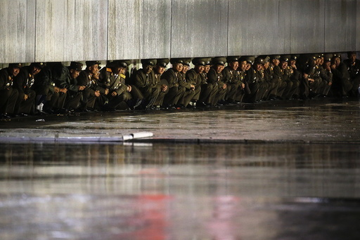 North Korean officers shield themselves from the rain after the parade celebrating the 70th anniversary of the founding of the ruling Workers' Party of Korea, in Pyongyang