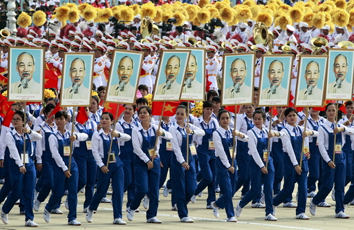 Workers carry portraits of late Vietnamese revolutionary leader Ho Chi Minh during a parade marking their 70th National Day at Ba Dinh square in Hanoi, Vietnam