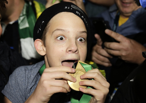 A boy displays the winners' medal given to him by Sonny Bill Williams of New Zealand after the Rugby World Cup Final against Australia at Twickenham in London