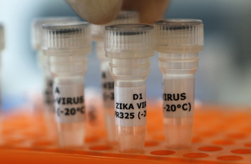 An employee examines tubes with the label 'Zika virus' at Genekam Biotechnology AG in Duisburg