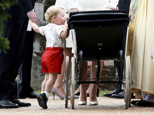 Britain's Prince George looks into the pram of his sister Princess Charlotte after her christening at the Church of St. Mary Magdalene in Sandringham