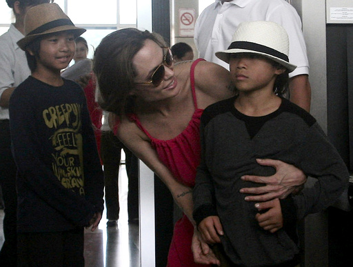 Hollywood actress Angelina Jolie chats with her adopted son Pax Thien at a security check point before leaving Con Dao island