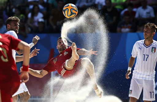 Gomez of Spain kicks the ball next to Marinai of Italy during their group stage beach soccer match at the 1st European Games in Baku