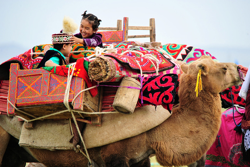 Children play on the camel during a traditional sports meeting in Barkol Kazakh Autonomous County