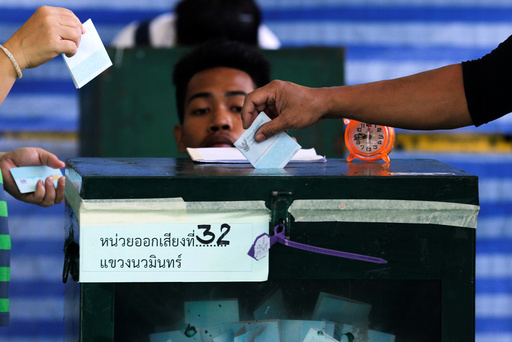 People cast their ballot papers during the referendum on a draft constitution at a polling station in Bangkok