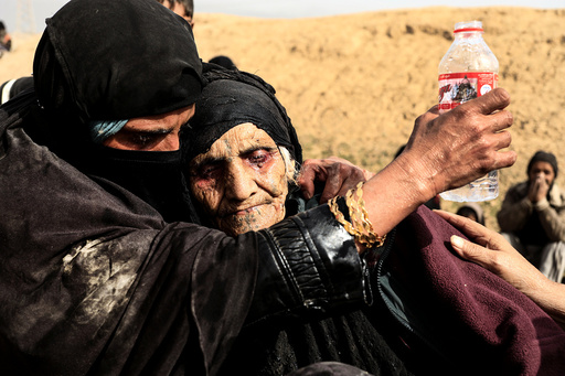 Displaced Iraqi women who just fled their home,rest in the desert as they wait to be transported while Iraqi forces battle with Islamic State militants in western Mosul