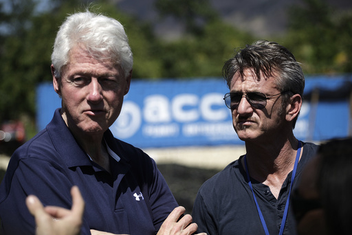 Former U.S. President Clinton and actor Penn listen to explanations by cooperative members of a local for-profit farming cooperative supporting agricultural development, during a tour to the Lime nursery, on the outskirts of Mirebalais