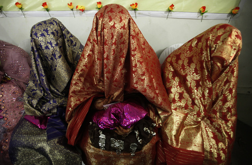 Brides sit together during a mass wedding ceremony in Peshawar