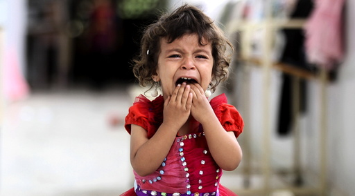 A girl cries as she walks onto the veranda at the yard of a school sheltering people displaced by Saudi-led air strikes on Yemen's northwestern province of Saada, in the capital Sanaa