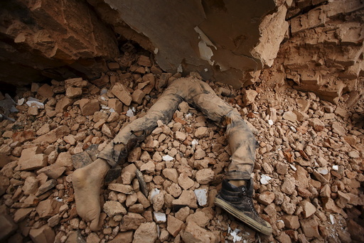 Body of a victim lies trapped in the debris after an earthquake hit, in Kathmandu