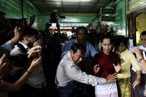 Myanmar's National League for Democracy party leader Aung San Suu Kyi reacts as some cameramen fell to the floor before casting her ballot during the general election in Yangon