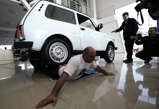Yajian reacts as a four wheel car drives over him during his attempt to break a Guinness record in Tbilisi