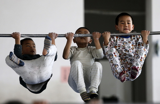 Young gymnasts practice pull-up on a bar at a gymnasium of a sports school in Jiaxing