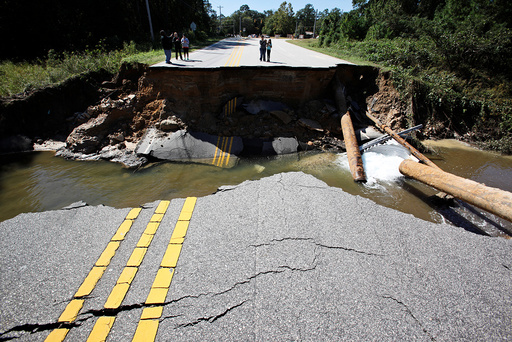 Residents inspect a washed-out section of collapsed road after Hurricane Matthew hit the state, in Fayetteville, North Carolina
