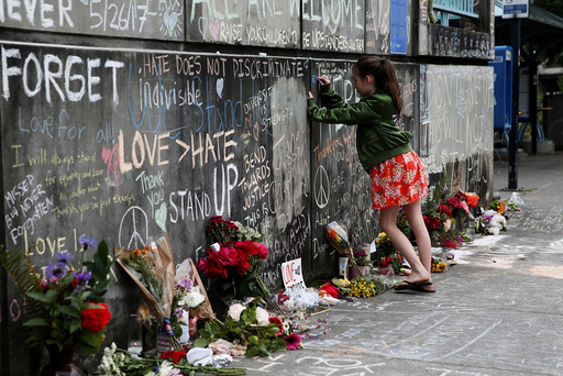A girl leaves a message at a makeshift memorial for two men who were killed on a commuter train while trying to stop another man from harassing two young women who appeared to be Muslim, in Portland